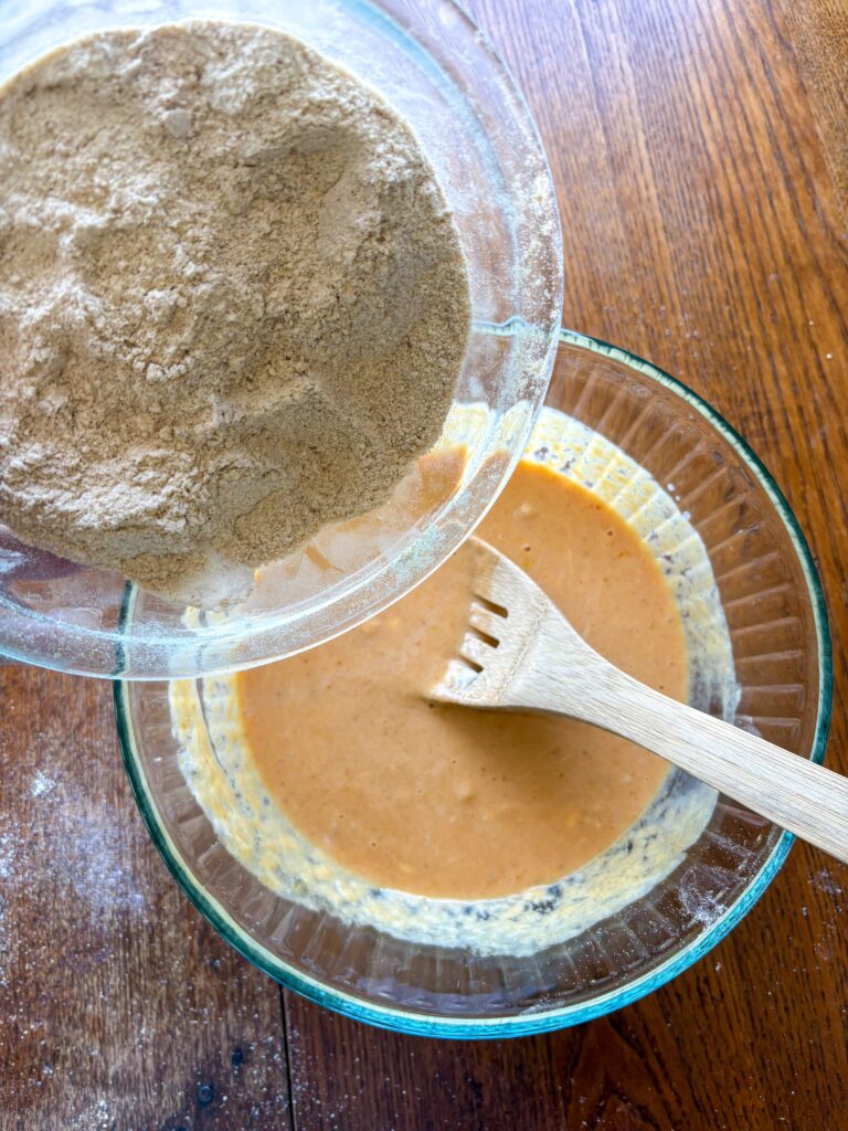 glass bowl with pumpkin mixture and another glass bowl with flour mixture on a kitchen table