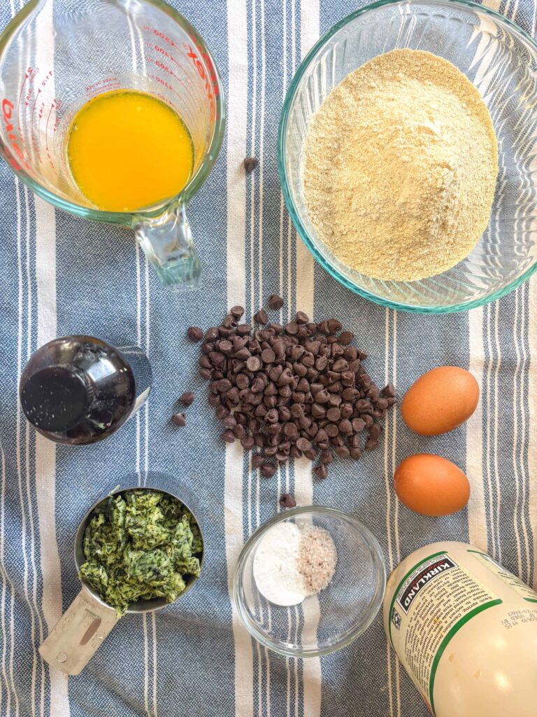 ingredients for zucchini muffins on a blue and white pinstripe tea towel