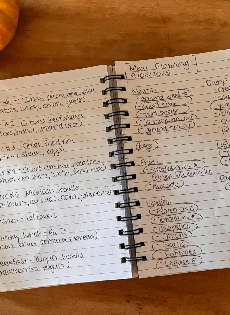Picture of notebook with meal plan written on it and heirloom tomato