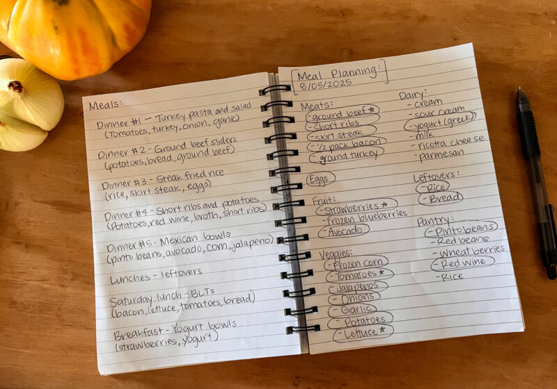 Picture of notebook with meal plan written on it and heirloom tomato