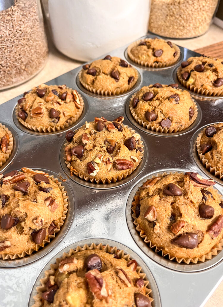 banana bread muffins with chocolate chips and pecans in a stainless steel muffin pan