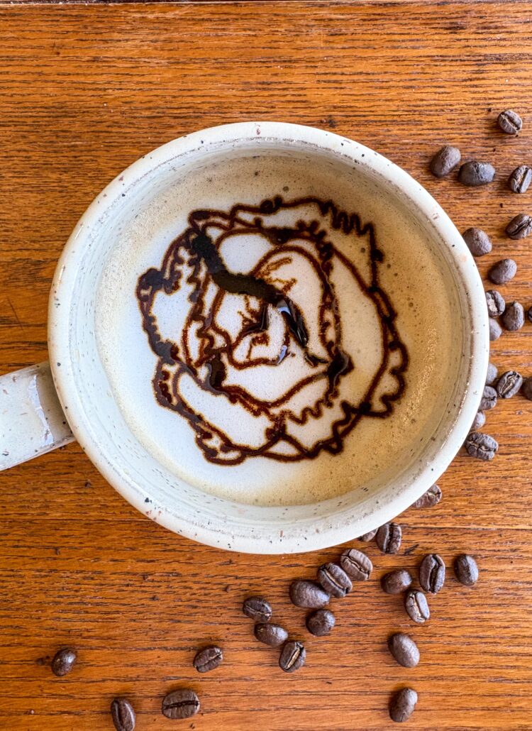 creamy blackstrap molasses latte in a mug on a kitchen table with coffee beans