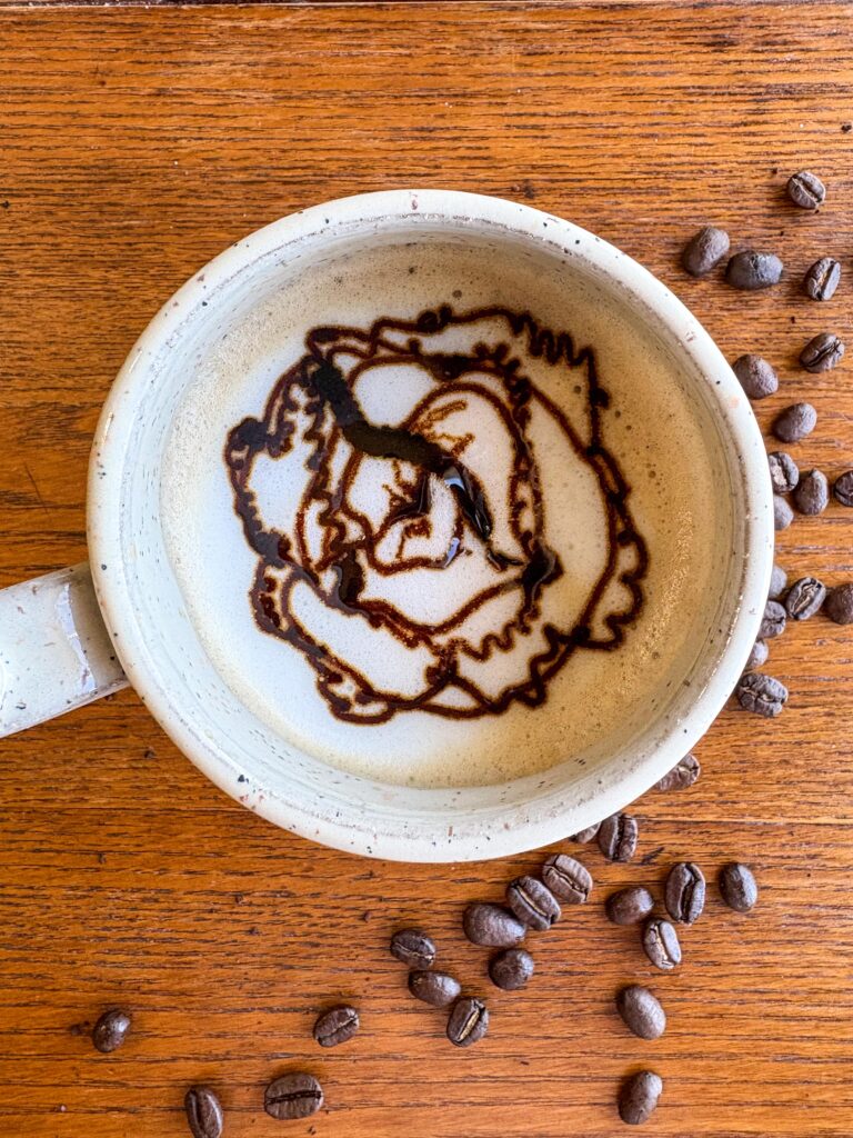 creamy blackstrap molasses latte in a mug on a kitchen table with coffee beans