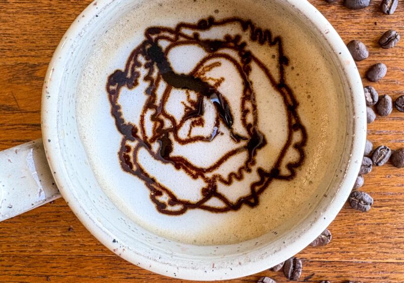 creamy blackstrap molasses latte in a mug on a kitchen table with coffee beans