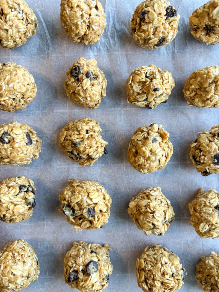 peanut butter energy balls on parchment paper in a line
